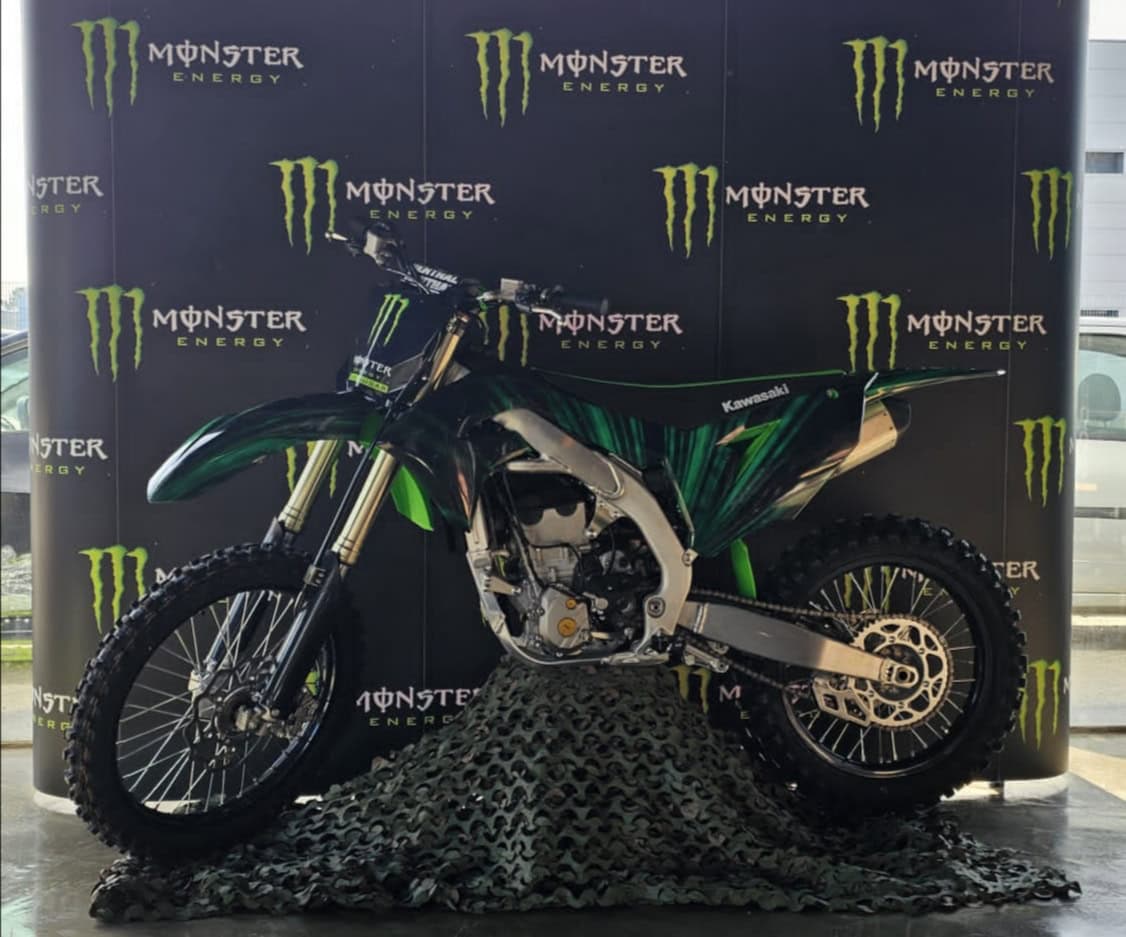 Motocross Kawasaki com design em verde e preto, destaque para energia Monster Energy.