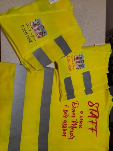 Colete refletor amarelo com logotipo da colónia de férias O Dom Maior, ideal para segurança e visibi.