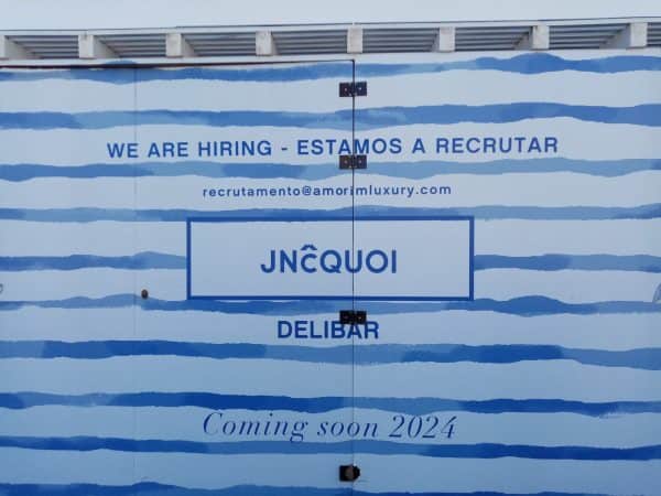 Vinil aplicado em tapumes com design de listras azuis, promovendo estética moderna e proteção na obr.