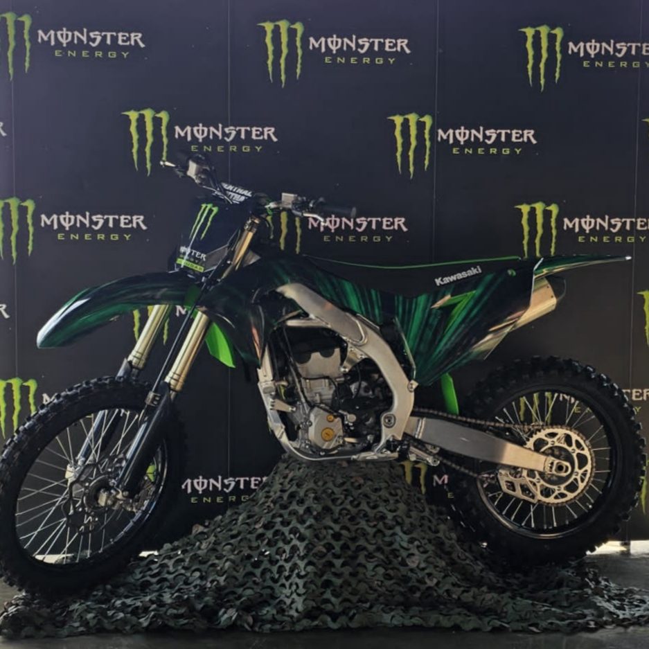 Motocross Kawasaki com design em verde e preto, destaque para energia Monster Energy.