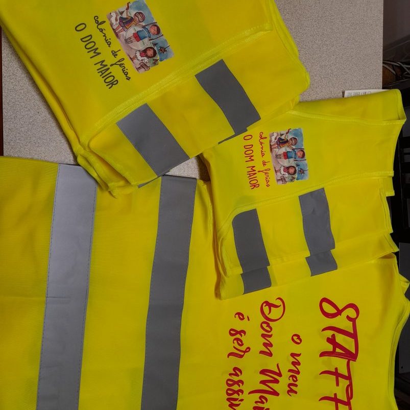 Colete refletor amarelo com logotipo da colónia de férias O Dom Maior, ideal para segurança e visibi.